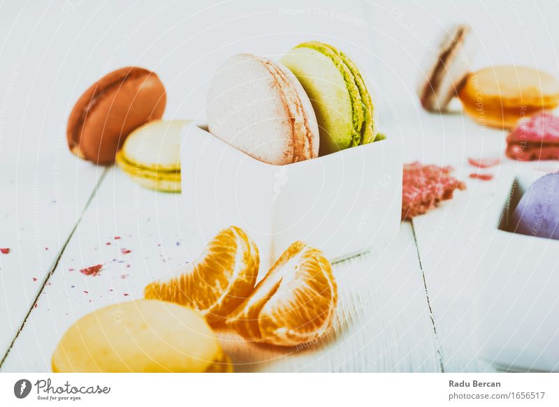 Französische Makronen mit Tangerine Slices auf hölzerner Tabelle Lebensmittel Frucht Orange Dessert Süßwaren Macaron Ernährung Essen Frühstück Tisch Diät