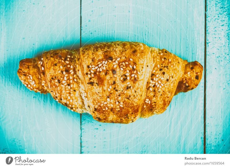 Croissant auf blauem Tisch Lebensmittel Ernährung Essen Frühstück füttern einfach nah süß mehrfarbig gelb gold türkis Holztisch Wald Französisch Backwaren Snack