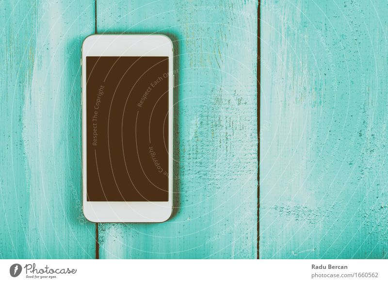 Weißer Handy mit leerem Bildschirm auf hölzerner Tabelle Telefon MP3-Player Technik & Technologie Unterhaltungselektronik High-Tech Telekommunikation