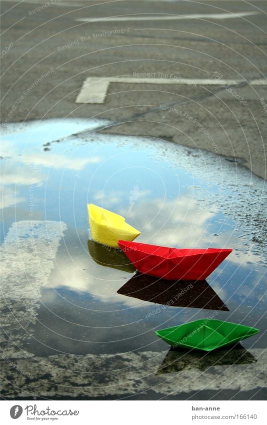 Schiffbruch Farbfoto Menschenleer Tag Wasser nass gelb grün rot Freude Papier Papierschiff Spielen Reflexion & Spiegelung See Parkplatz Pfütze Im Wasser treiben