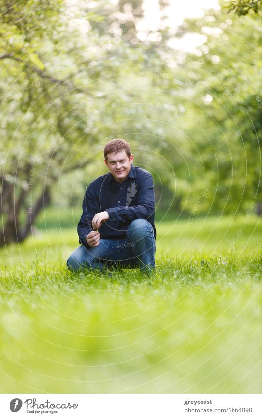 Lächelnder Mann mittleren Alters, der sich im Stadtpark ausruht. Schöne Bokeh Hintergrund. Lifestyle Glück Erholung Windstille Sommer Garten Mensch Erwachsene 1