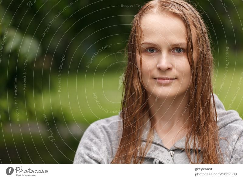 Porträt eines Mädchens, das nach dem Regen im Park zum Fotografen schaut, mit Kopierraum auf der linken Seite. Lifestyle Glück schön Gesicht Sommer Mensch