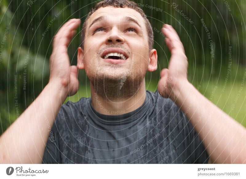 Junger unrasierter Mann, der unter dem Regen nass wird. Lifestyle Gesicht Mensch Junger Mann Jugendliche Erwachsene Arme 1 18-30 Jahre Wetter Unwetter Park