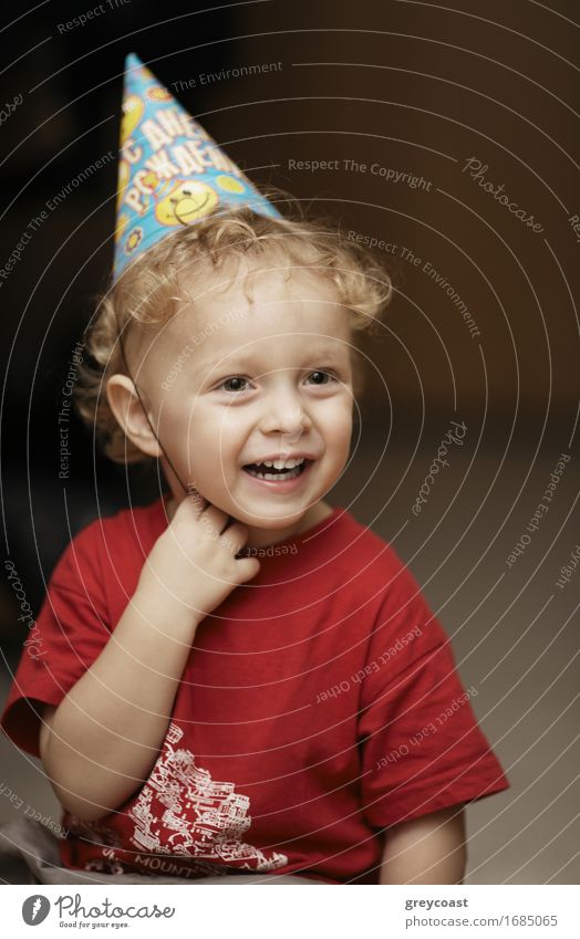 Nette glückliche junge Junge in einer Partei Hut lachen mit Freude, wie er einen Geburtstag oder Weihnachten feiert Lifestyle Glück schön Gesicht