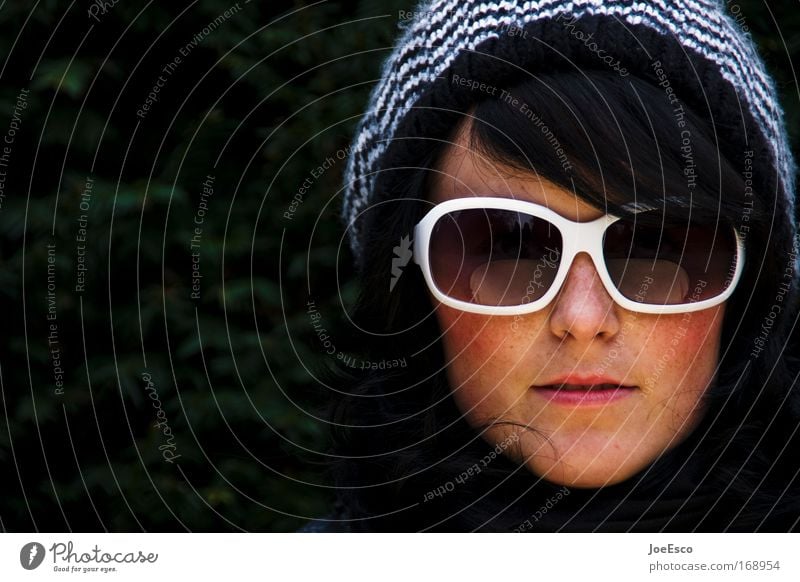 sonnenbrille und pudelmütze Farbfoto Außenaufnahme Textfreiraum links Tag Porträt Blick Blick in die Kamera feminin Frau Erwachsene Kopf Haare & Frisuren