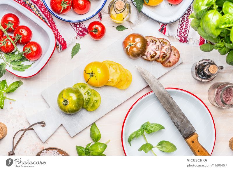 Scheiben von bunten Tomaten mit Messer Lebensmittel Gemüse Salat Salatbeilage Kräuter & Gewürze Öl Ernährung Mittagessen Abendessen Büffet Brunch Festessen