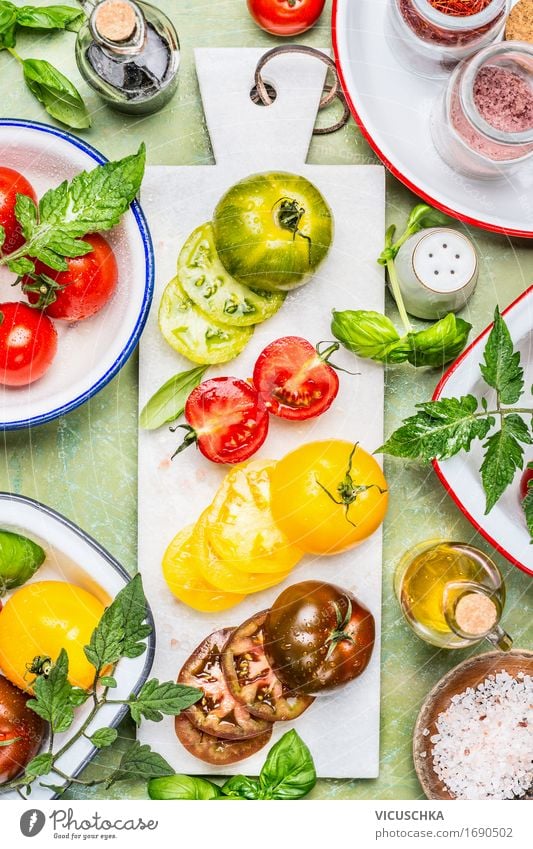 Bunte Tomaten in Scheiben geschnitten mit Kochzutaten Lebensmittel Gemüse Salat Salatbeilage Kräuter & Gewürze Öl Ernährung Mittagessen Abendessen Büffet Brunch