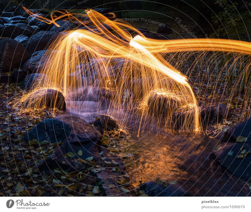 Lichtmalerei Natur Landschaft Feuer Wasser Park Bach gelb orange Funken Nacht Nachtaufnahme Langzeitbelichtung leuchten dunkel Dämmerung Leuchtspur Farbfoto