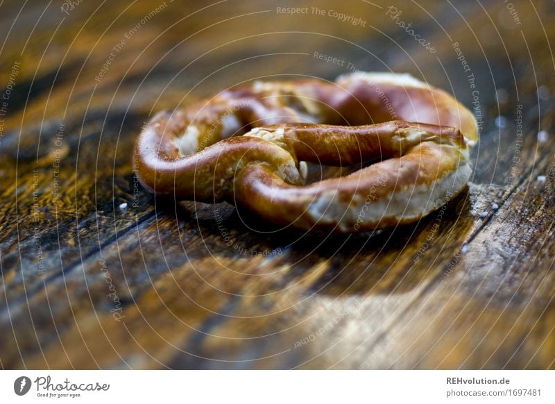 A Brezn Lebensmittel Ernährung lecker Brezel bayerisch Oktoberfest Backwaren Tisch Holz geschmackvoll Salz Farbfoto Gedeckte Farben Außenaufnahme Nahaufnahme