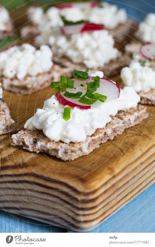 Knäckebrot mit Hüttenkäse Radieschen und Kräutern Kräuter & Gewürze Holz blau Schnittlauch Dill Petersilie rote bete blätter Holzbrett Snack gesunder snack