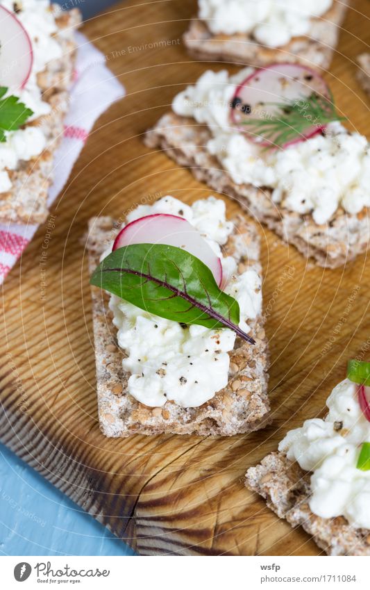 Knäckebrot mit Hüttenkäse Radieschen und Kräutern Kräuter & Gewürze Holz blau Schnittlauch Dill Petersilie rote bete blätter Holzbrett Snack gesunder snack