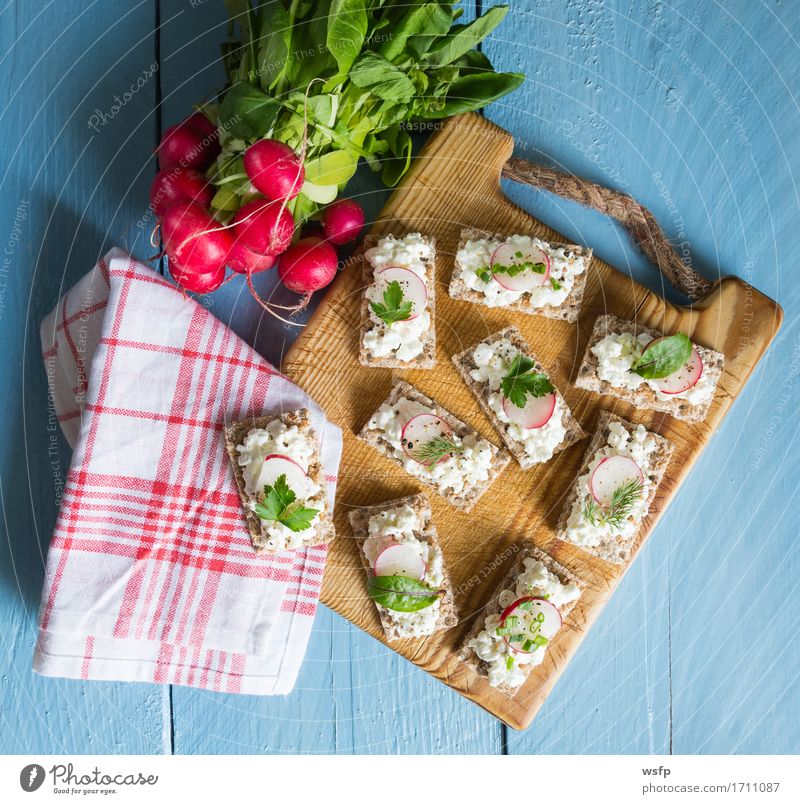 Knäckebrot mit Hüttenkäse Radieschen und Kräutern Kräuter & Gewürze Holz blau Schnittlauch Dill Petersilie rote bete blätter Holzbrett Snack gesunder snack