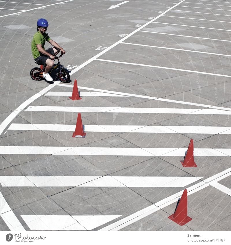 Slalom Baby! Slalom! Gedeckte Farben Außenaufnahme Strukturen & Formen Sonnenlicht maskulin Mann Erwachsene fahren Fahrrad Linie Helm üben lernen Rad Parkplatz