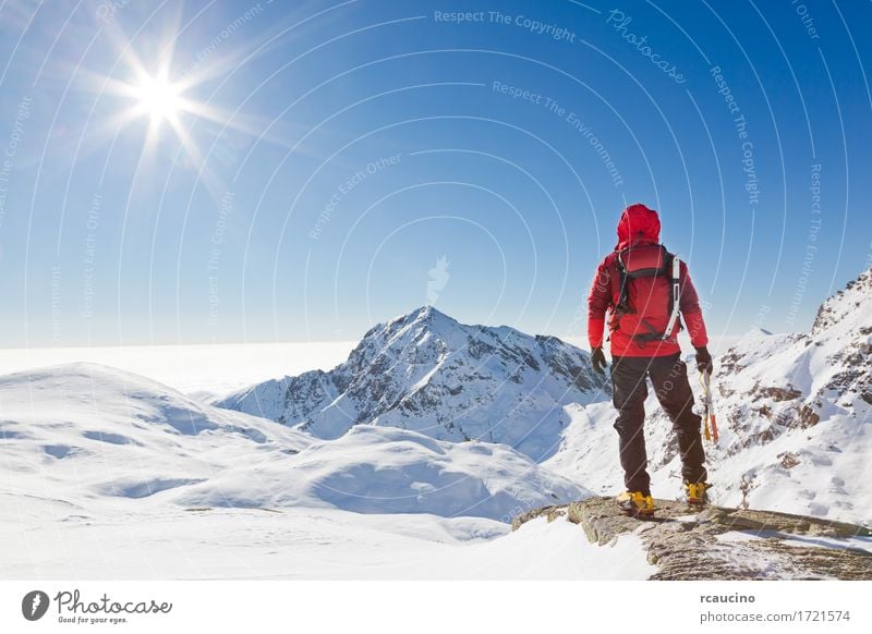 Mountaineer erreicht die Spitze eines schneebedeckten Berges Abenteuer Expedition Sonne Winter Schnee Berge u. Gebirge Sport Klettern Bergsteigen Erfolg Mann