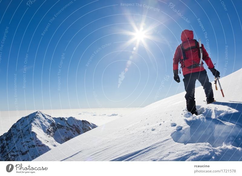 Mountaineer erreicht die Spitze eines schneebedeckten Berges Abenteuer Expedition Sonne Winter Schnee Berge u. Gebirge Sport Klettern Bergsteigen Erfolg Mann