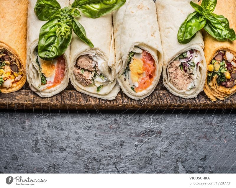 Leckere Tortilla Wraps auf dunklem Hintergrund Lebensmittel Fisch Gemüse Brot Ernährung Mittagessen Büffet Brunch Picknick Bioprodukte Vegetarische Ernährung