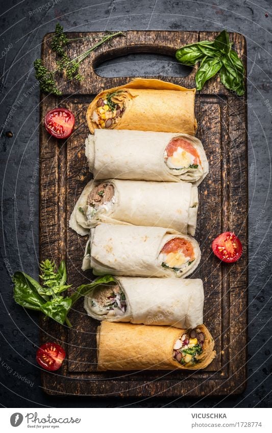 Verschiedene leckere Tortilla Wraps auf rustikalem Schneidebrett Lebensmittel Gemüse Salat Salatbeilage Kräuter & Gewürze Ernährung Mittagessen Abendessen