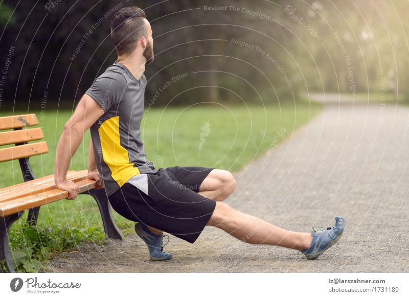 Junger Mann, der in einen Park ausdehnt Lifestyle Körper Sport maskulin Erwachsene 1 Mensch 18-30 Jahre Jugendliche Fitness Aktion anonym Bank Textfreiraum Tun