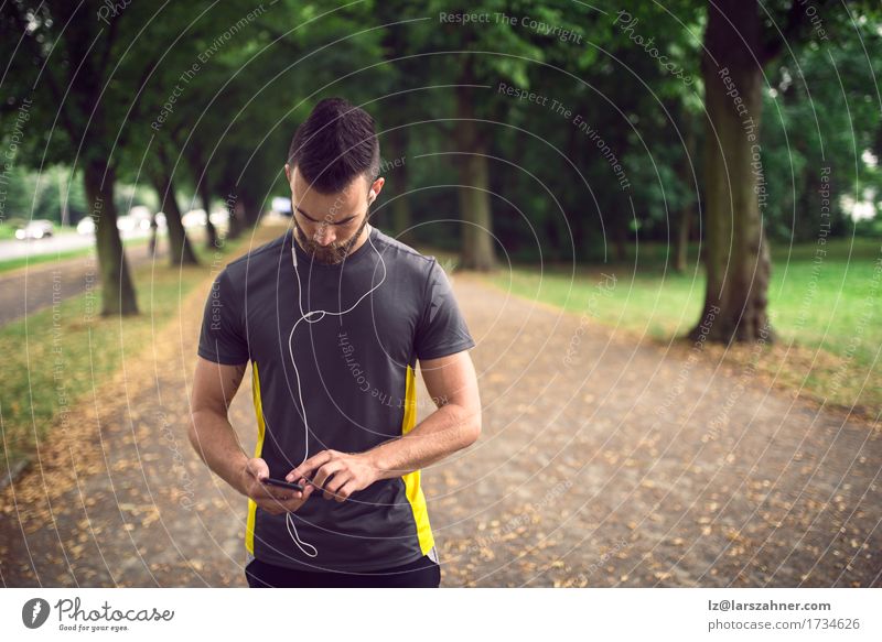 Attraktiver bärtiger Mann, der Musik hört Lifestyle Gesicht lesen Sport Telefon PDA Erwachsene 1 Mensch 18-30 Jahre Jugendliche Park Fitness hören sportlich