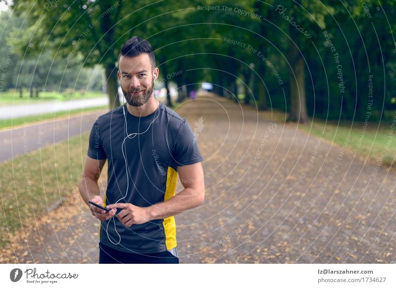 Attraktiver bärtiger Mann, der Musik hört Lifestyle Gesicht Sommer Sport Telefon PDA Erwachsene 1 Mensch 18-30 Jahre Jugendliche Park Fitness hören Lächeln