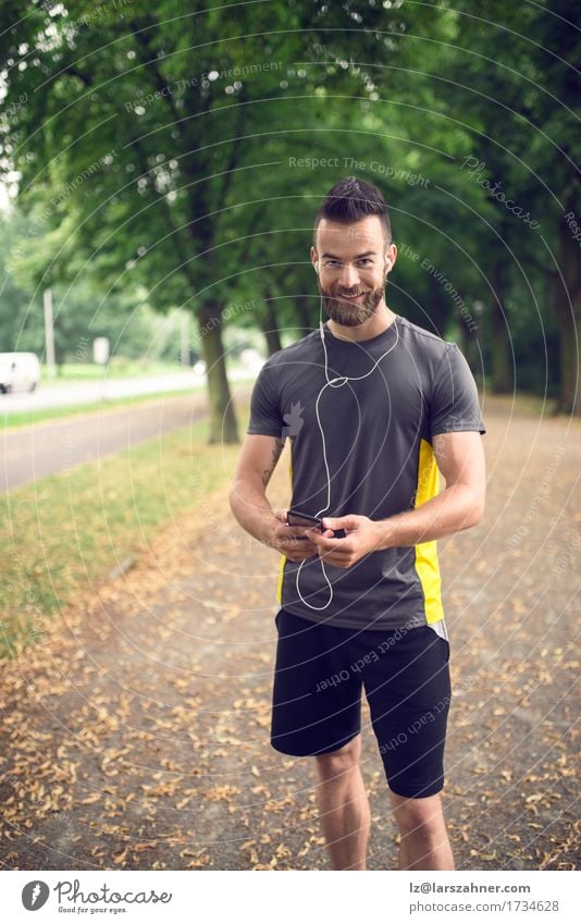 Attraktiver bärtiger Mann, der Musik hört Lifestyle Gesicht Sommer Sport Telefon PDA Erwachsene 1 Mensch 18-30 Jahre Jugendliche Park Fitness hören Lächeln