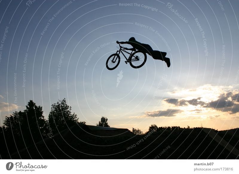 Superman Außenaufnahme Dämmerung Silhouette Sonnenlicht Sonnenaufgang Sonnenuntergang Gegenlicht Totale Funsport Fahrradfahren fliegen Sport Coolness blau