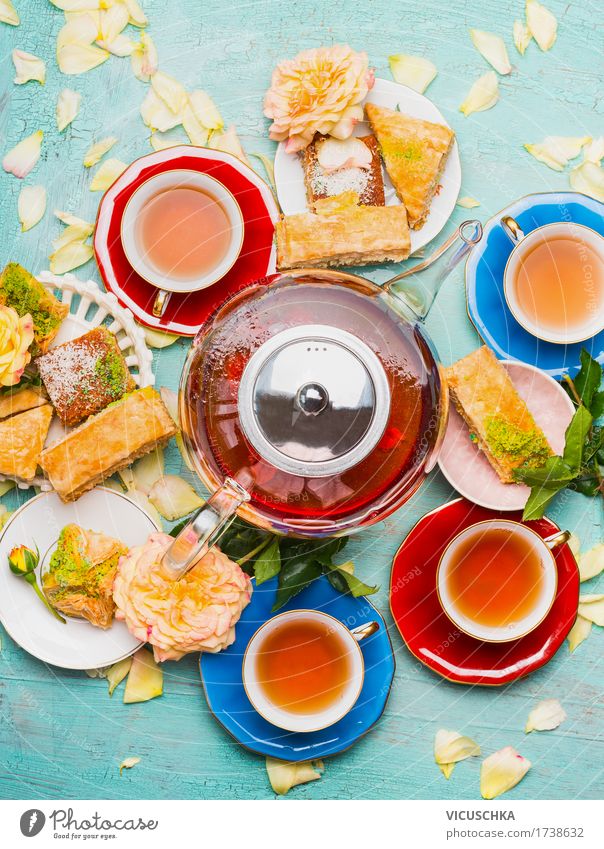 Teepause mit Tassen , Blumen , Kuchen und Teekanne Lebensmittel Dessert Frühstück Mittagessen Getränk Heißgetränk Geschirr Teller Stil Design Häusliches Leben