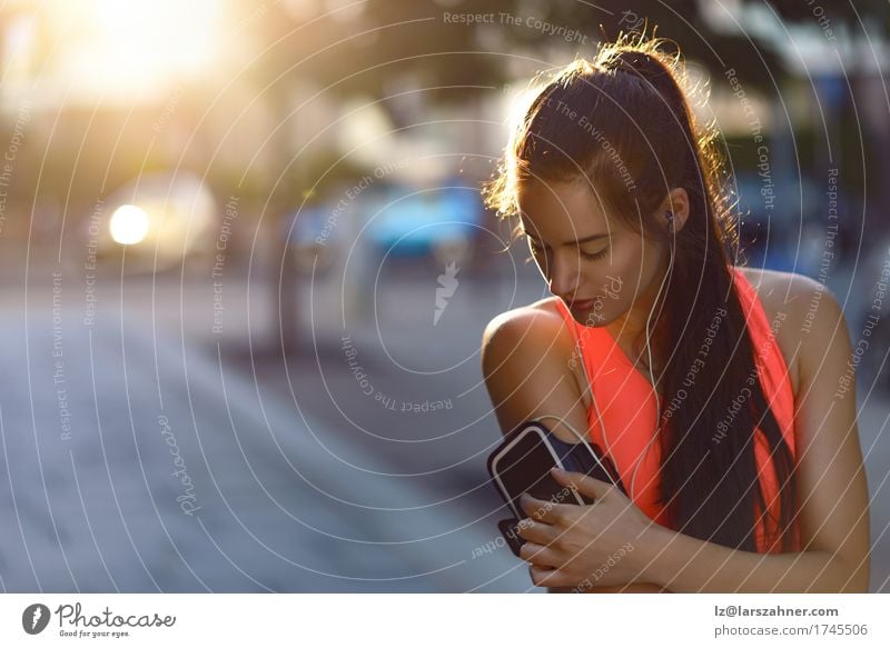 Frau Jogger überprüft ihr Musik Gerät Lifestyle schön Gesicht Sport PDA Erwachsene Kleinstadt Straße brünett sportlich niedlich attraktiv Überprüfung Entwurf