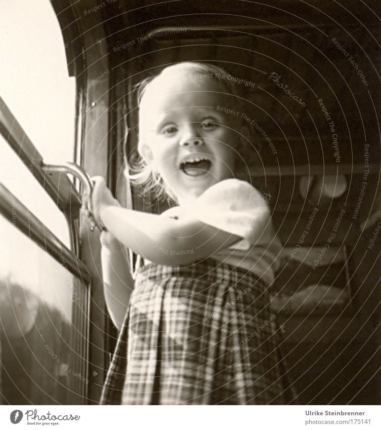 Kleines lachendes Mädchen steht am offenen Zugfenster Schwarzweißfoto Innenaufnahme Tag Oberkörper Blick in die Kamera Mensch Kind 1 3-8 Jahre Kindheit