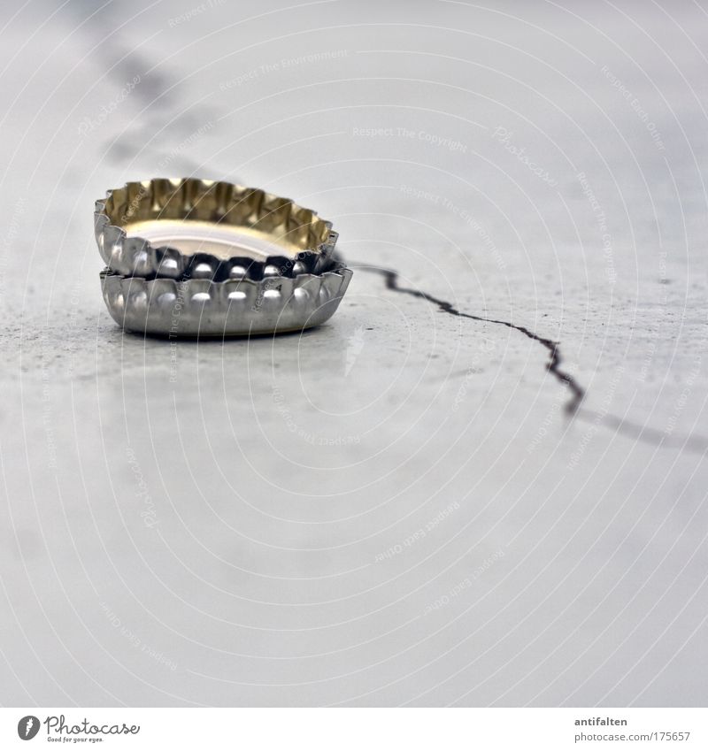 2 Kronkorken auf der Mauer Metall alt trist gold grau silber Farbfoto Gedeckte Farben Außenaufnahme Nahaufnahme Textfreiraum unten Hintergrund neutral Tag