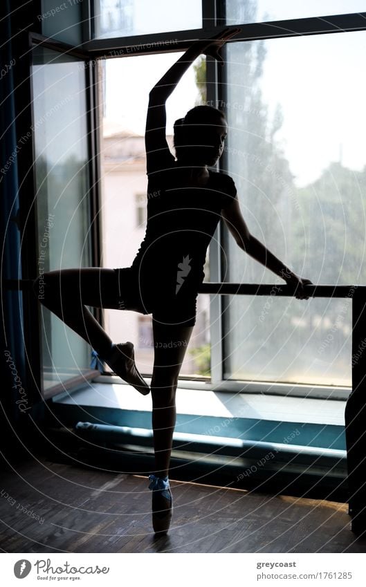 Schwarze Silhouette einer Balletttänzerin in Position an der Stange in der Nähe des Fensters Tanzen Schule Studium Mädchen Jugendliche 13-18 Jahre Tänzer