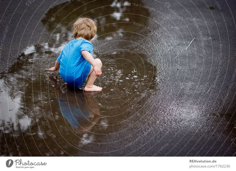 Kind spielt in einer Pfütze Spielen Mensch maskulin Junge 1 3-8 Jahre Kindheit Sommer Herbst Wetter schlechtes Wetter Regen Straße T-Shirt Wasser hocken