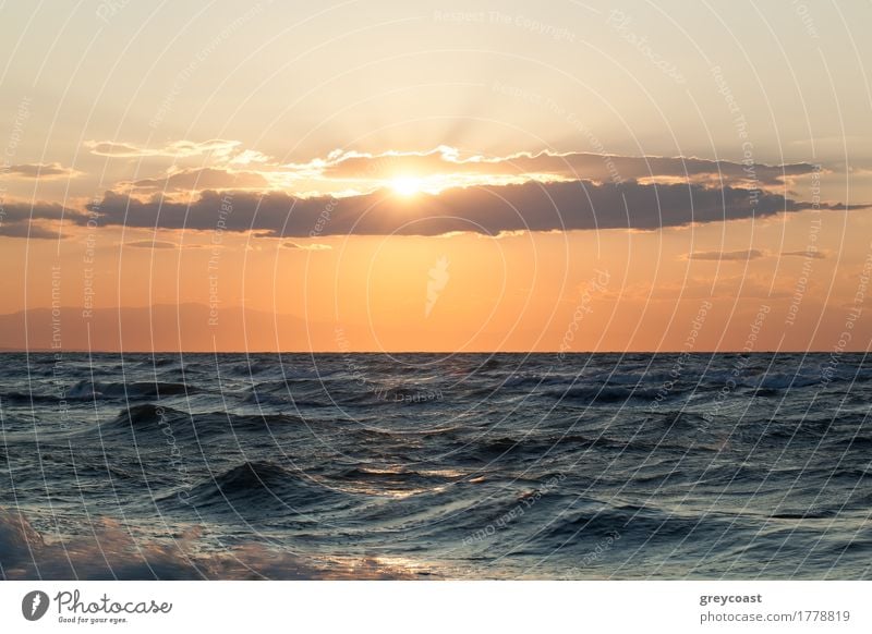 Blick auf das raue, wellige Meer und die Abendsonne, die durch die Wolken scheint schön Sonne Natur Landschaft Himmel Horizont Unwetter Wind Küste Beileid