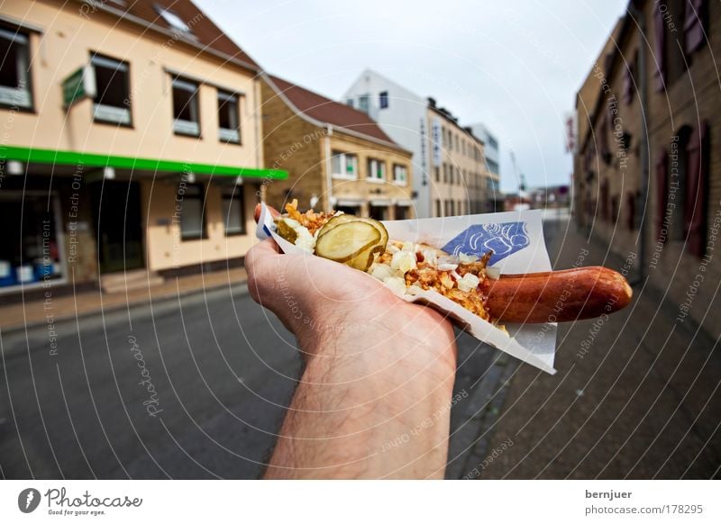 Hand hält einen Hotdog festhalten Wurstwaren Ernährung Lebensmittel Finger lecker Fleisch gegrillt Papier Snack Saucen Küche take away Fastfood Ketchup