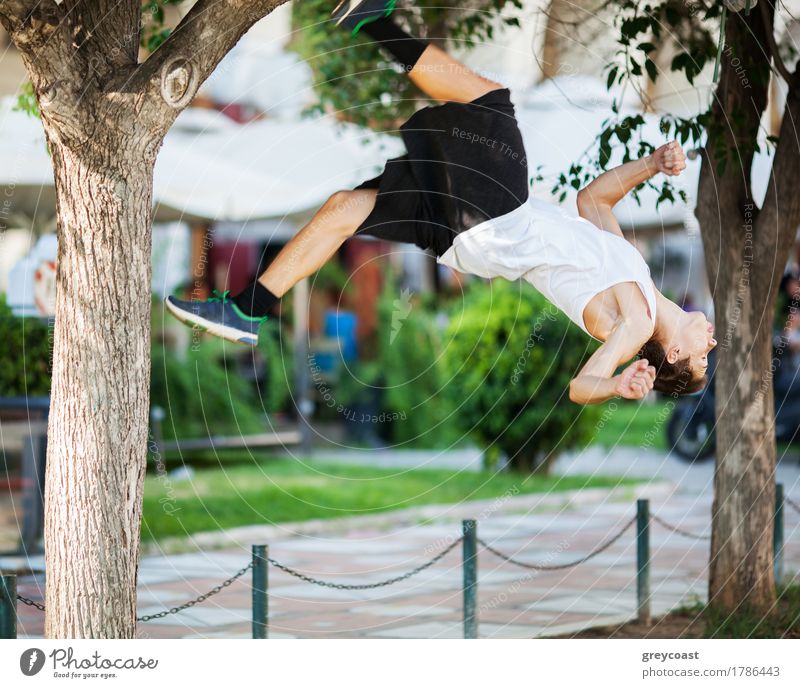 Bewegungsaufnahme eines jungen Sportlers, der in der Stadt Akrobatik betreibt. Frontflip-Trick Lifestyle Sommer Mensch Mann Erwachsene Baum Straße springen frei