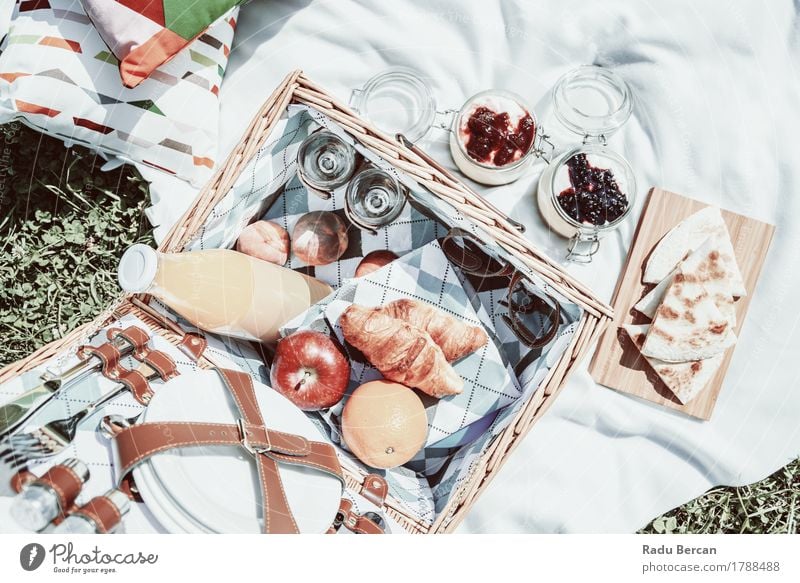 Glücklicher Picknickkorb und köstliches Lebensmittel im Frühjahr Frucht Apfel Orange Croissant Marmelade Ernährung Essen Frühstück Mittagessen Saft Geschirr