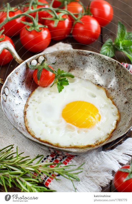 Spiegelei mit Tomaten und Kräutern Gemüse Essen Frühstück Abendessen Pfanne Tisch Holz frisch gelb grün rot Cholesterin braten Mahlzeit Protein rustikal