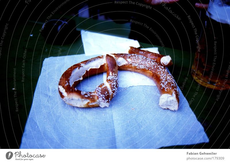 Brezn Lebensmittel Teigwaren Backwaren ausgehen trinken Jahrmarkt Biergarten blau braun Brezel Farbfoto Gedeckte Farben Außenaufnahme Tag Schatten Kontrast