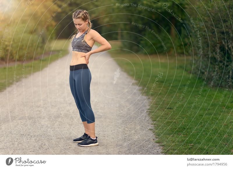 Sportlerin mit Schmerz in ihr zurück beim Laufen Gesicht Wellness Sommer Frau Erwachsene Hand 1 Mensch 18-30 Jahre Jugendliche Landschaft Pflanze Blatt T-Shirt