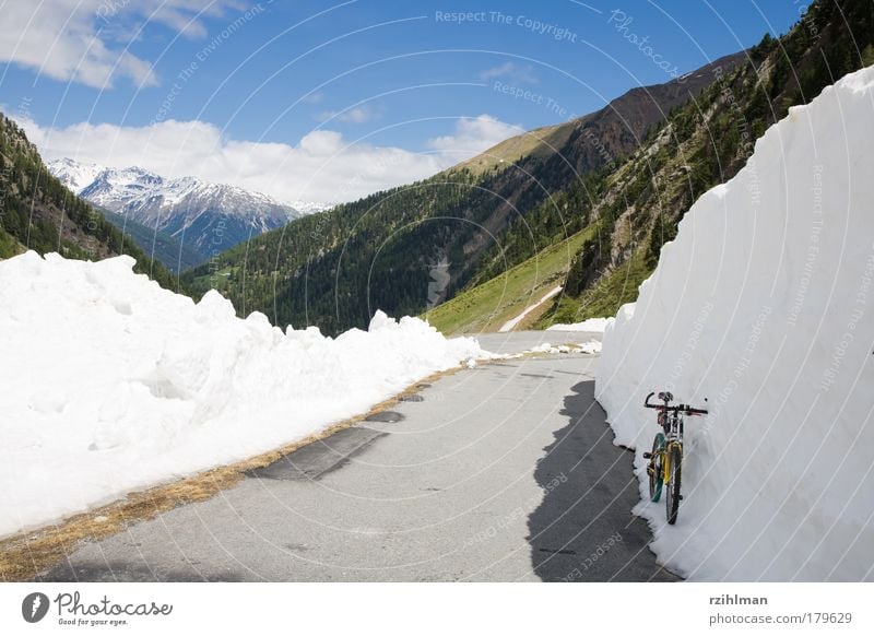 Schneewand am Umbrailpass Farbfoto Außenaufnahme Textfreiraum links Tag Sonnenlicht Berge u. Gebirge Fahrrad Wolken Hügel Felsen Alpen Wege & Pfade fahren blau