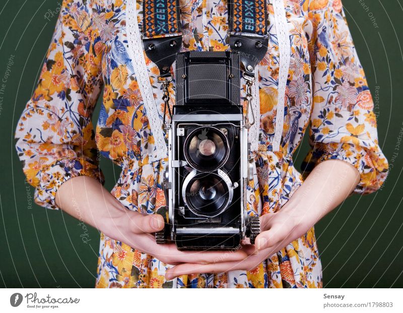 Weinlesekamera in der Hand auf Grün Stil schön Fotokamera Mensch Mädchen Frau Erwachsene Blume Mode Kleid alt retro grün rot weiß Farbe altehrwürdig Fotografie