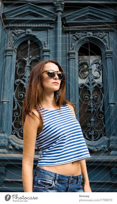 Mädchen, das auf dem alten Türhintergrund steht Stil Glück schön Sonne Mensch Frau Erwachsene Band Mode Hemd Jeanshose Sonnenbrille Holz Streifen stehen trendy