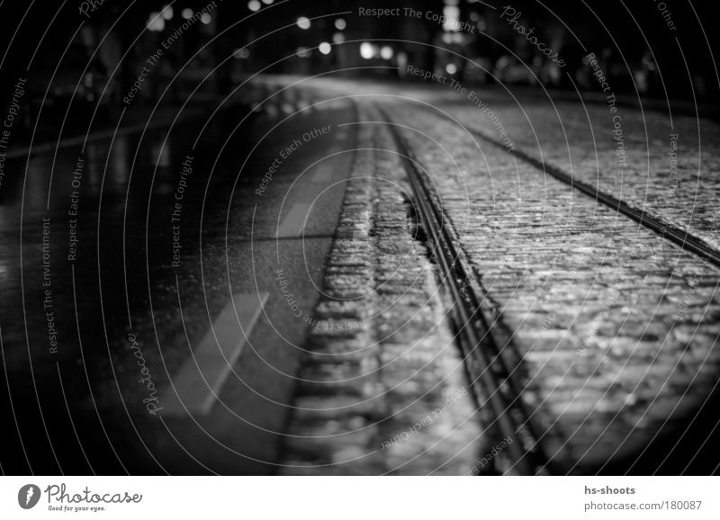 Bahngleise und Straße Schwarzweißfoto Nacht Froschperspektive Regen Freiburg im Breisgau Deutschland Stadt Verkehr Verkehrsmittel Verkehrswege Schienenverkehr