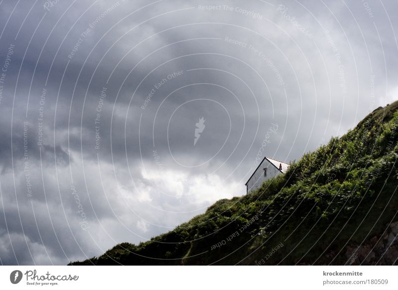 Und am Ende der Straße steht ein Haus am Meer Farbfoto Himmel Wolken Gewitterwolken Hügel Felsen Menschenleer Einfamilienhaus Traumhaus Gebäude Mauer Wand