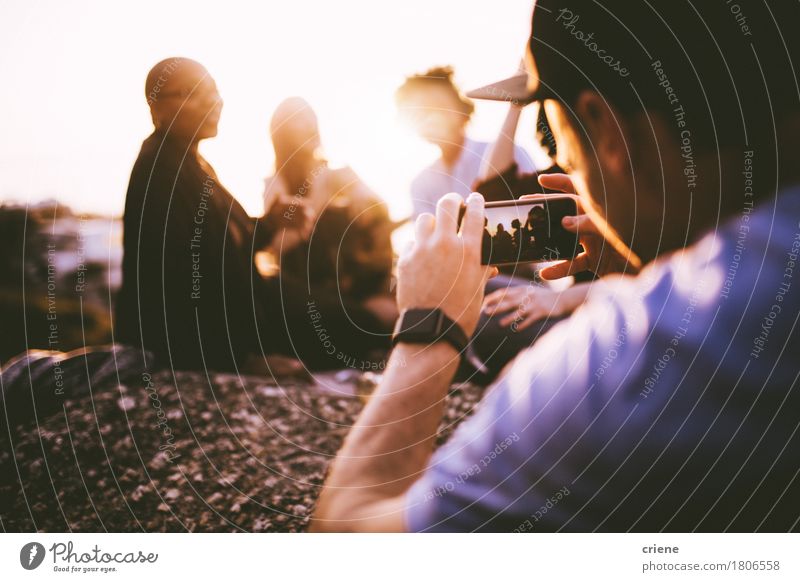 Junger erwachsener Mann, der Foto mit intelligentem Telefon seiner Freunde macht Lifestyle Freude Sommer Sonne Party ausgehen Feste & Feiern Fotokamera