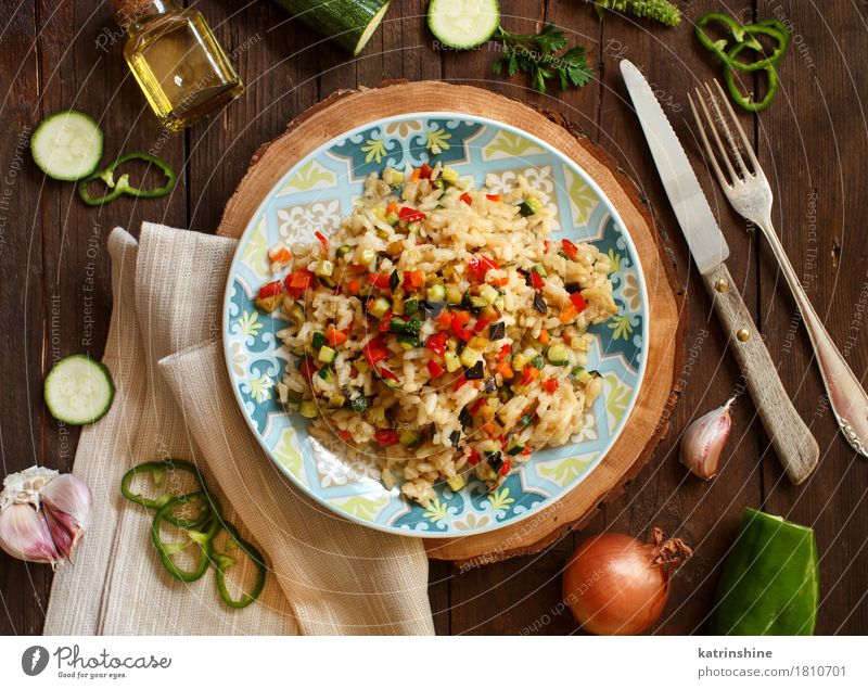 Risotto mit Gemüse Getreide Öl Ernährung Mittagessen Abendessen Vegetarische Ernährung Diät Italienische Küche Teller Flasche Gabel Holz lecker Koch