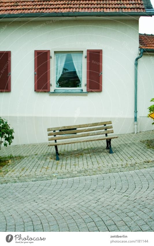 Bank vor Haus Parkbank Sitzgelegenheit leer ausdruckslos frei ruhig Ferien & Urlaub & Reisen Dorf Fassade Fenster Einfamilienhaus Fensterladen Gardine