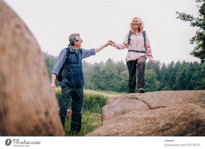 Älterer Mann, der seiner Frau einen Felsen auf Wanderung oben klettern hilft Lifestyle Freude Erholung Freizeit & Hobby Ferien & Urlaub & Reisen Tourismus