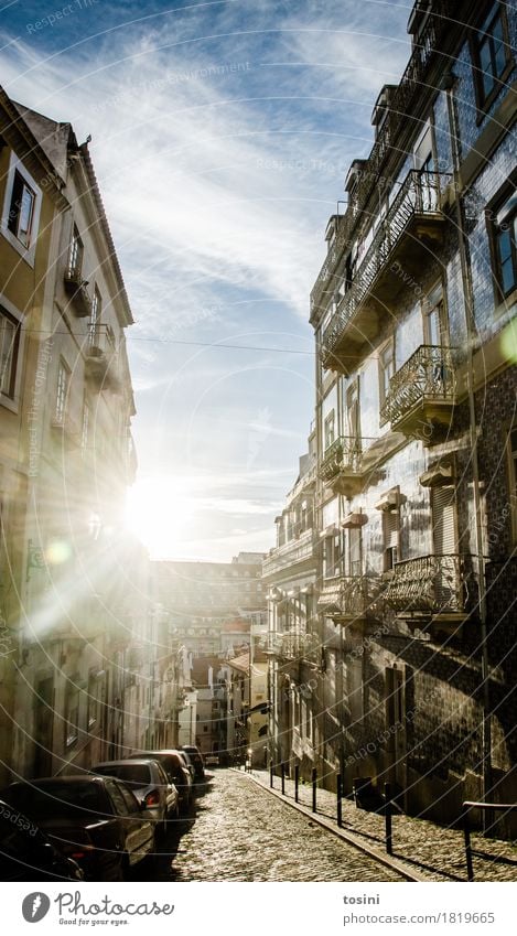 Straßenzug in Lissabon im Gegenlicht I Stadt Hauptstadt Haus blau Fassade Fliesen u. Kacheln Balkon PKW Wolkenhimmel hell Stadtleben Fenster Pflastersteine