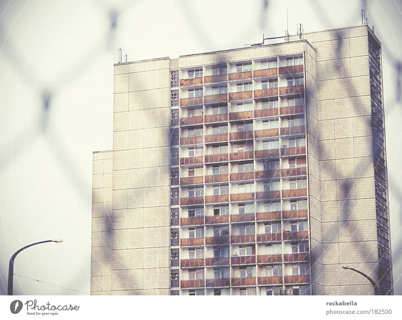 Hochhausansicht durch Maschendrahtzaun Gedeckte Farben Außenaufnahme Tag Stadt Haus Gebäude Architektur Mauer Wand Fassade Balkon alt einfach hoch